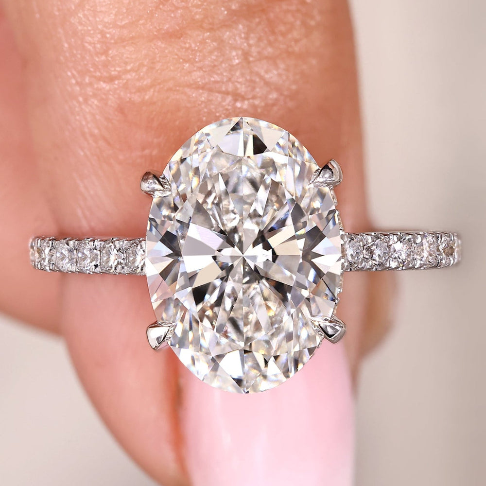 Oval engagement ring with pave band and open gallery.