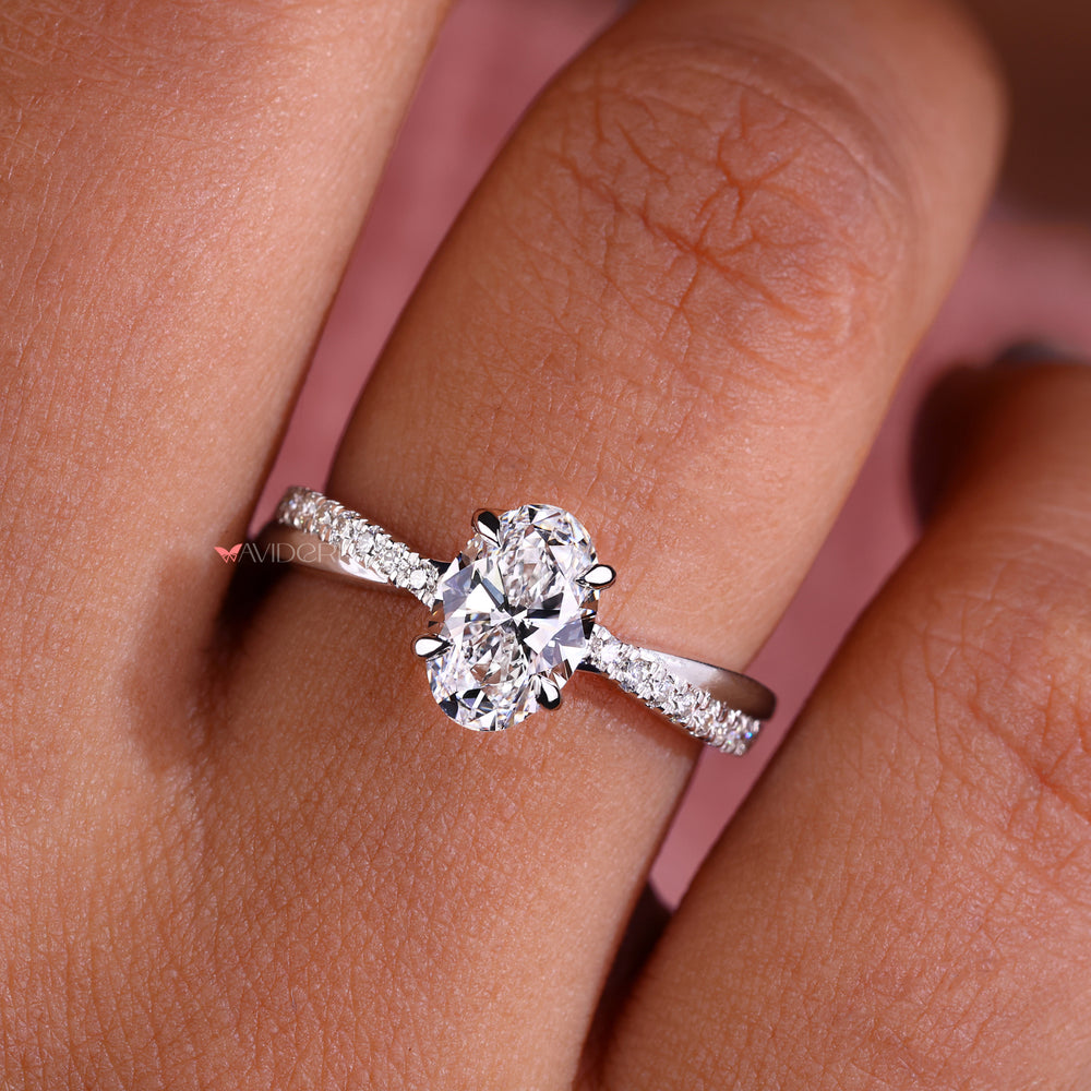 Avideri engagement ring featuring an oval diamond in a claw prong setting with a pave engagement ring band.
