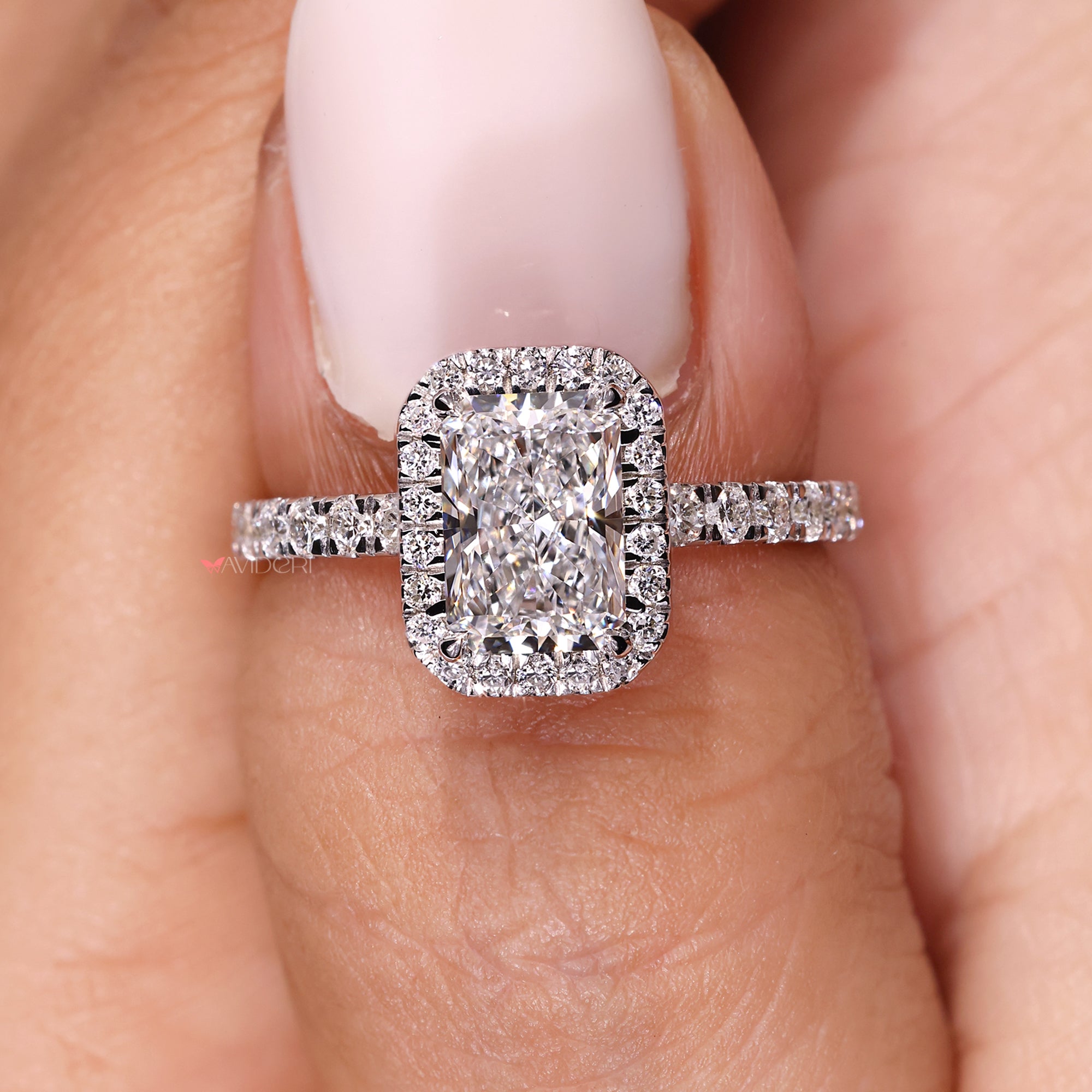 Elegant radiant cut ring with round pave and halo.