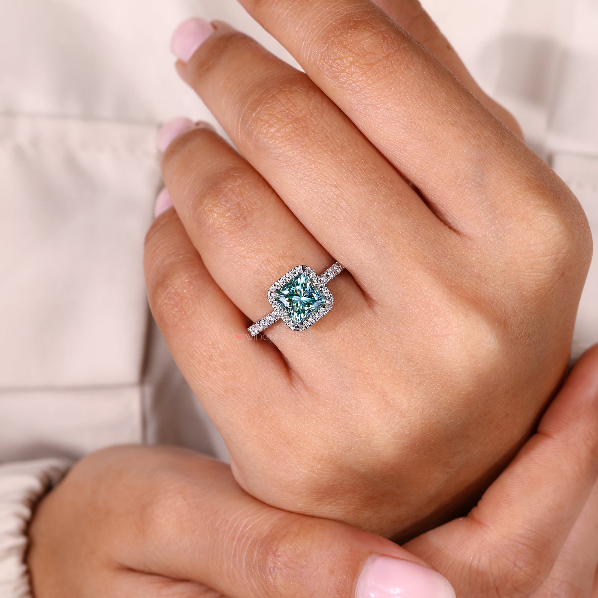 Close-up of a hand wearing a ring with on a light background