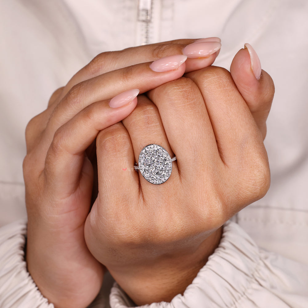 Cluster style engagement ring with round pave set diamonds.
