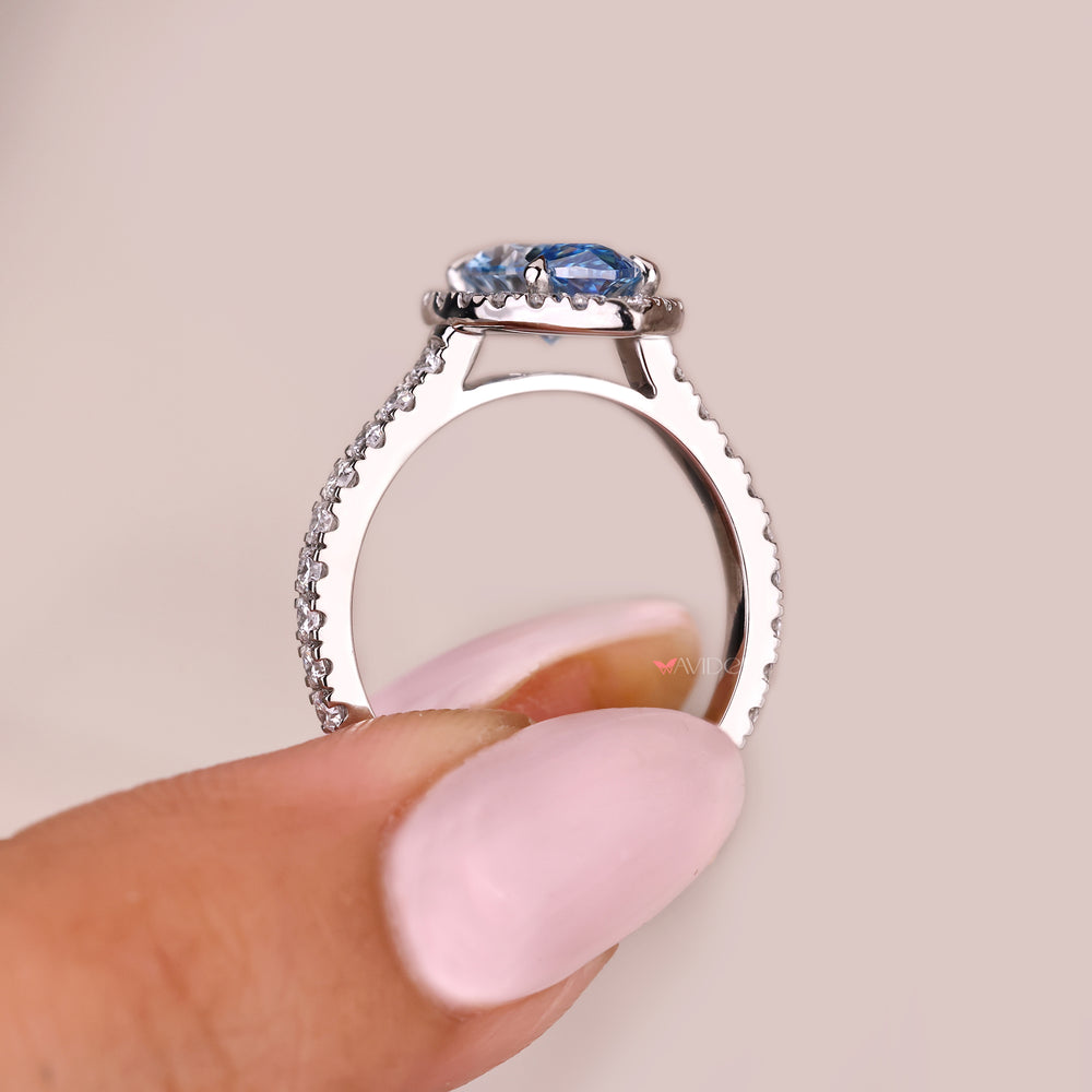 Blue marquise diamond ring with round diamond halo accents
