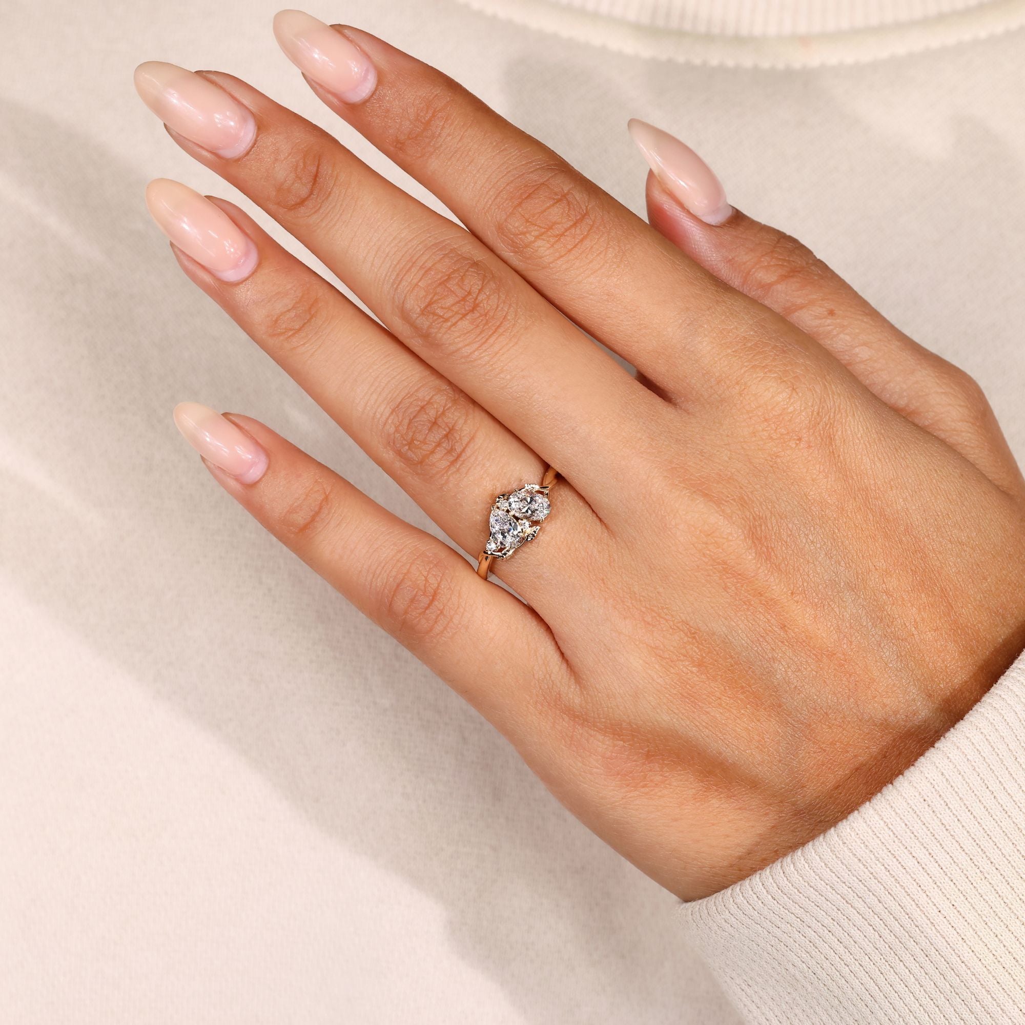 Pear and oval diamond ring with leaf style prongs.
