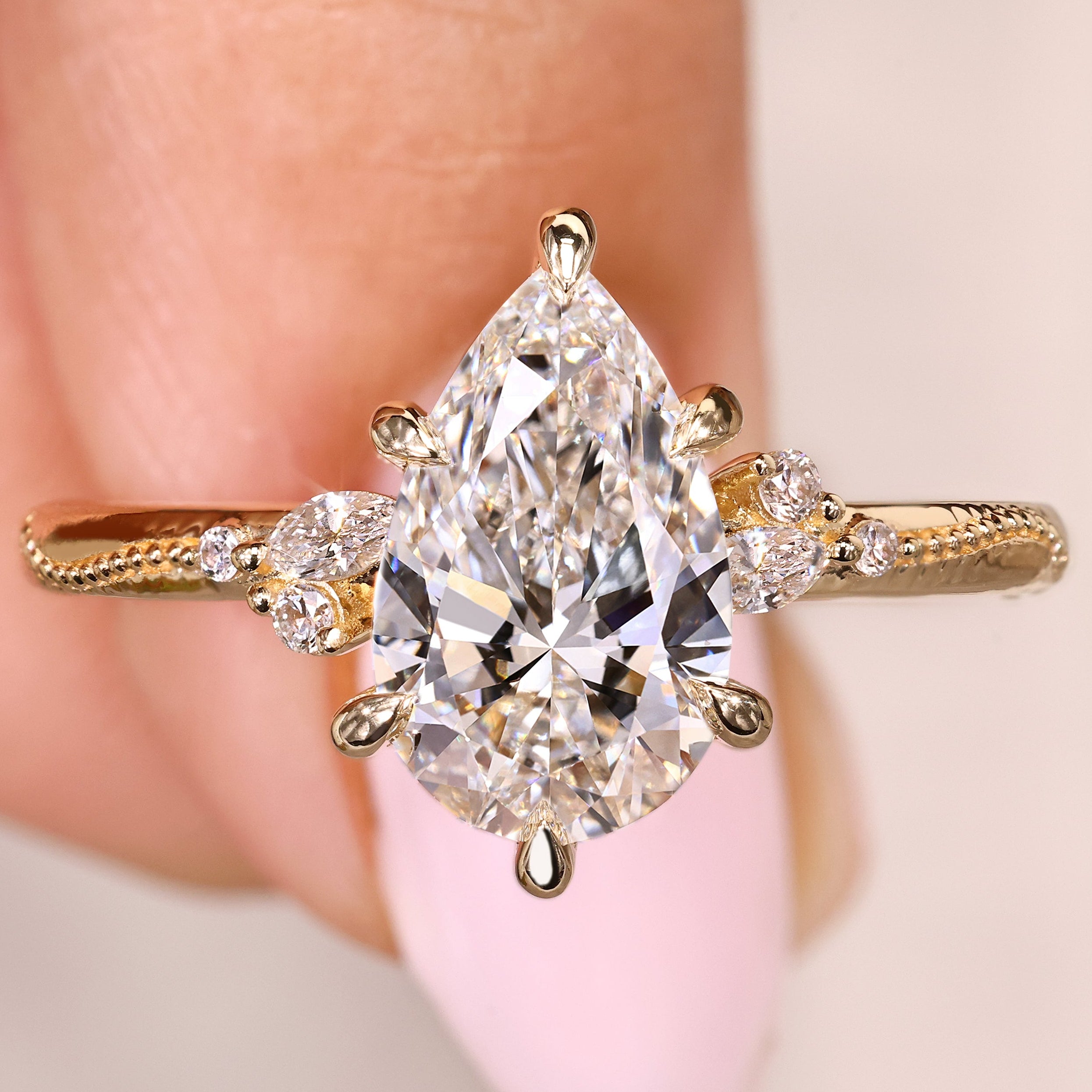 Pear cut diamond ring with marquise and round side stones

