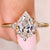Pear cut diamond ring with marquise and round side stones
