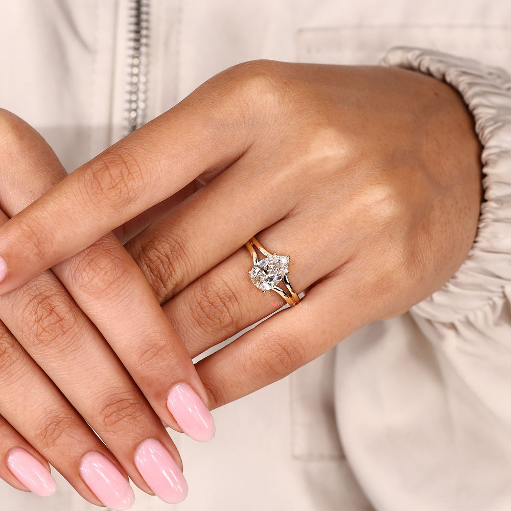 Pear cut lab grown diamond ring with hidden halo and split band.