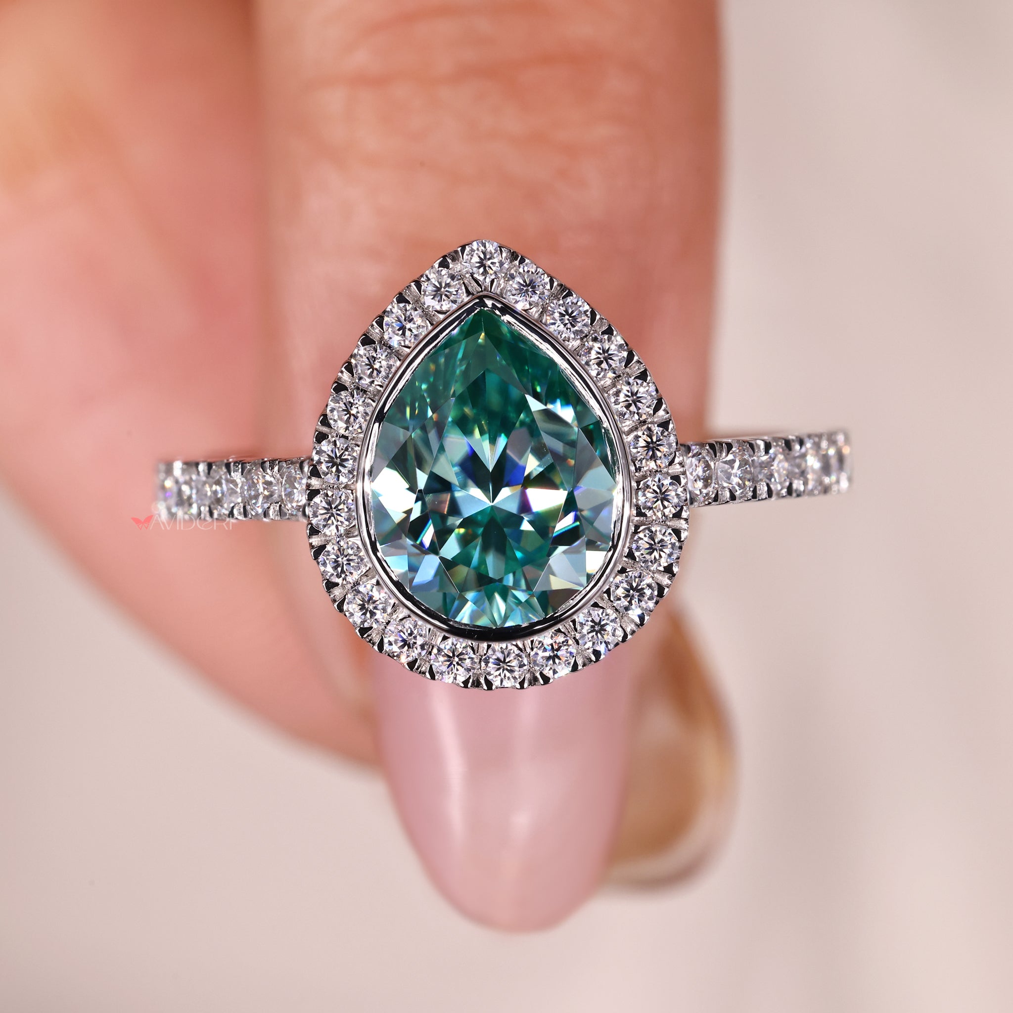 Handmade ring featuring a pear cut center stone in a gold bezel setting.