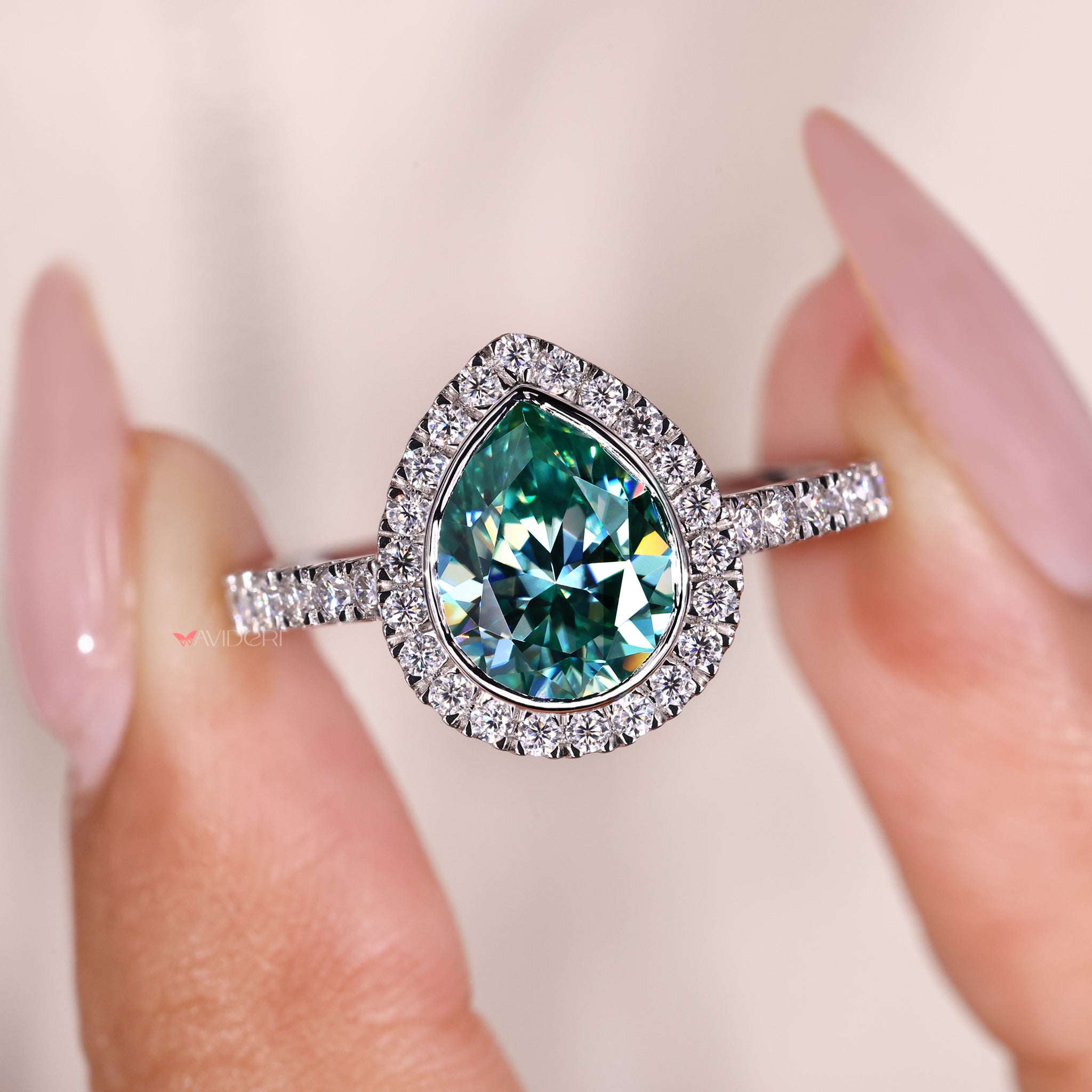Bezel setting ring showcasing a pear cut stone in white gold.
