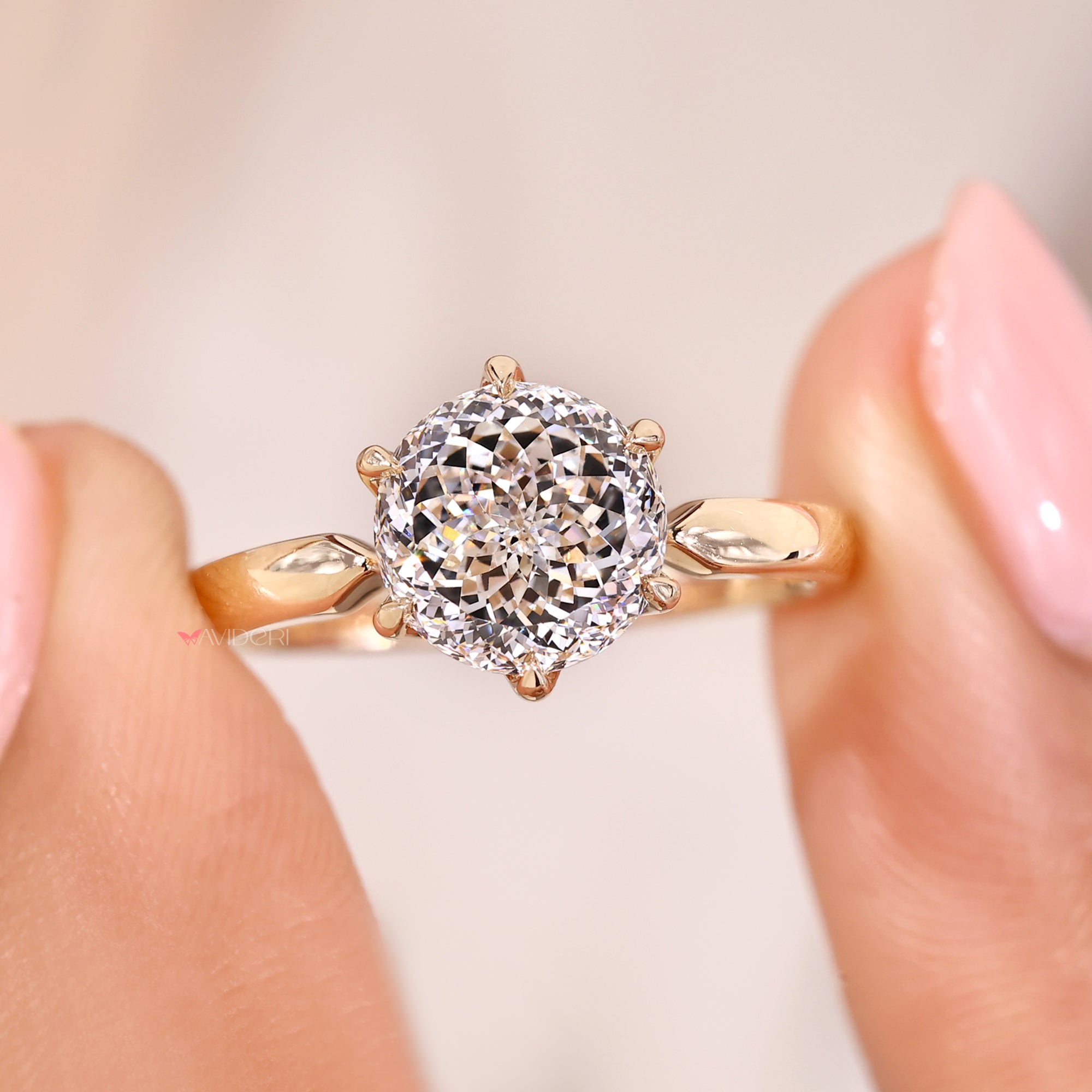 Solitaire diamond ring in yellow gold with pinched shank design.