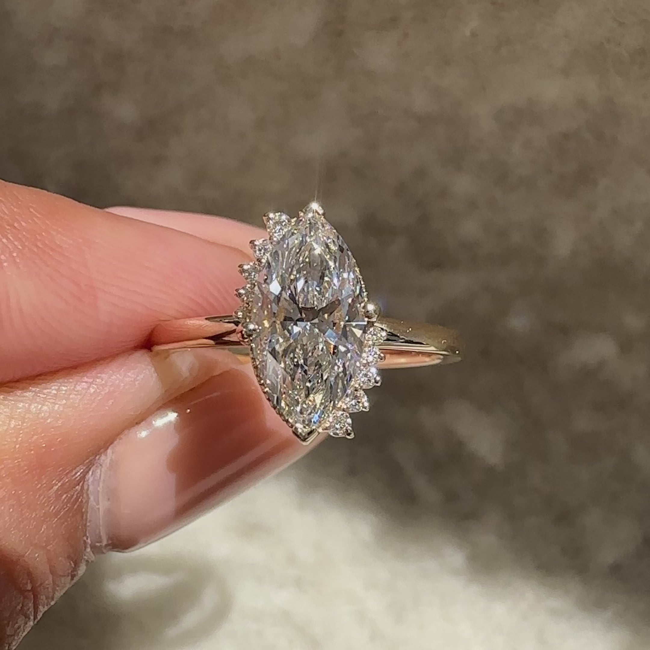 Marquise diamond ring with round stone cluster.