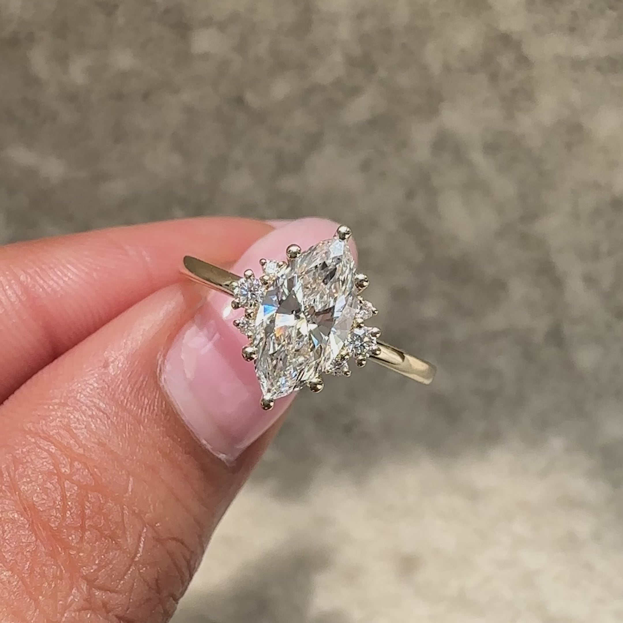 Marquise diamond ring with round side diamond accents.
