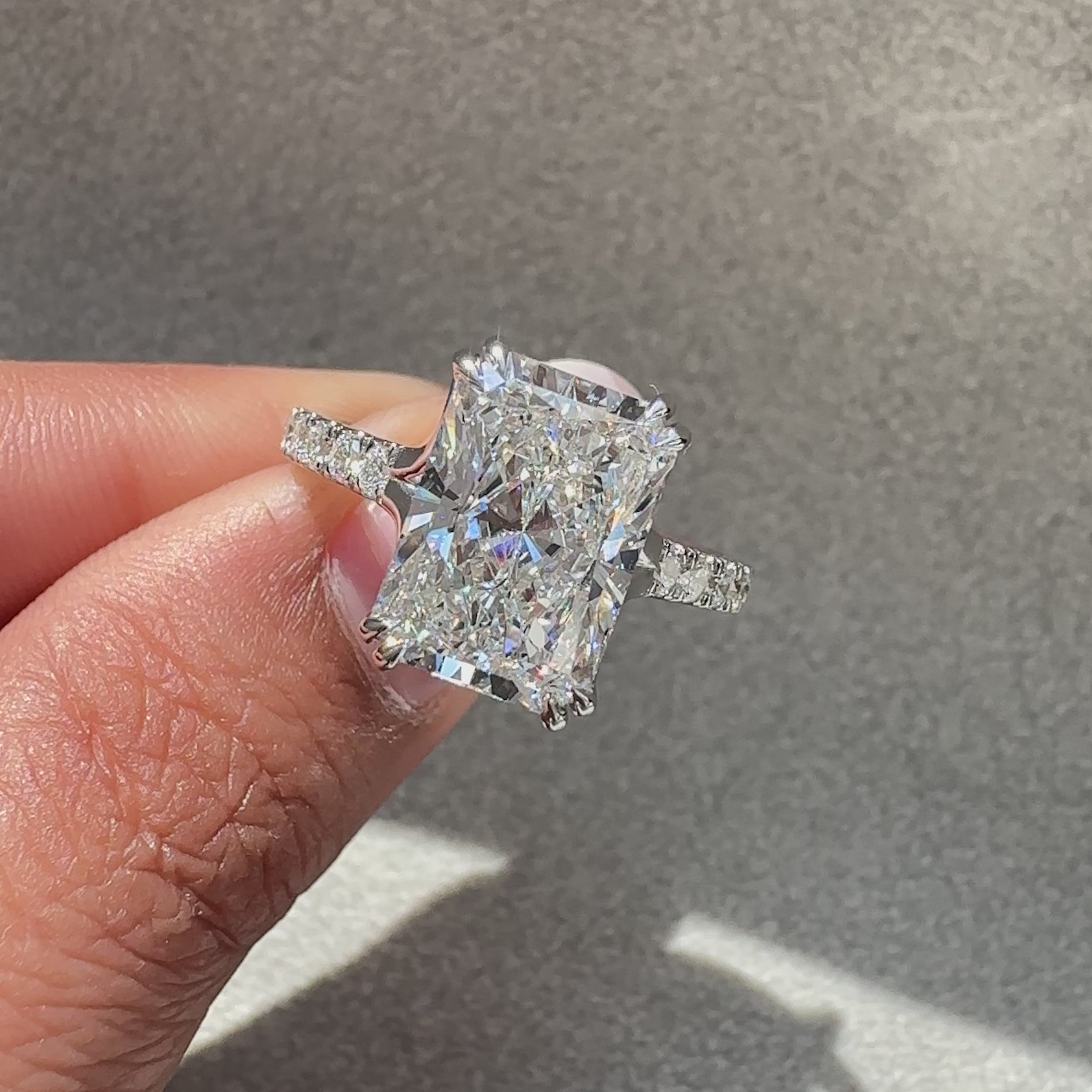 Radiant cut diamond ring with pave setting band.

