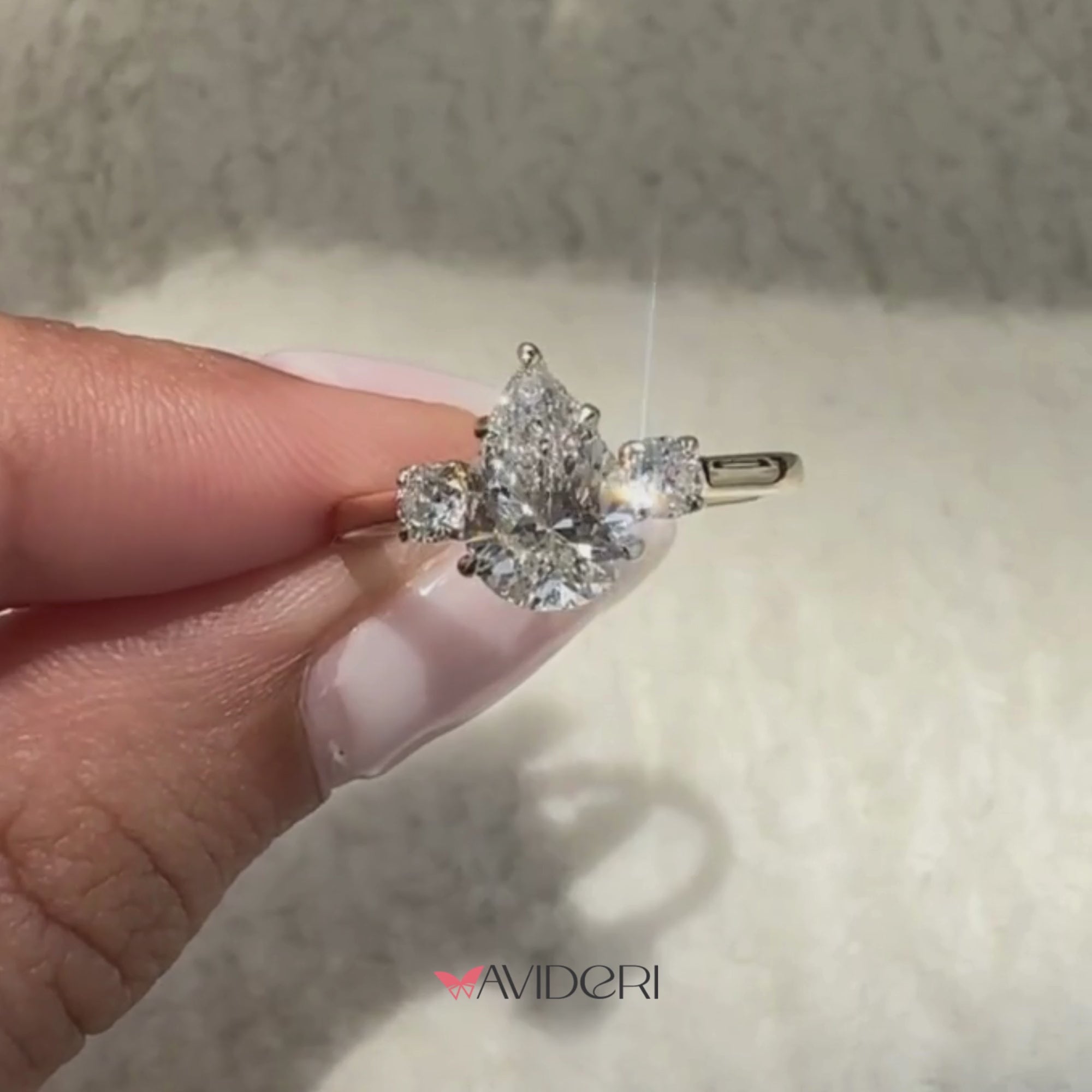 Pear cut lab grown diamond ring with round side stones
