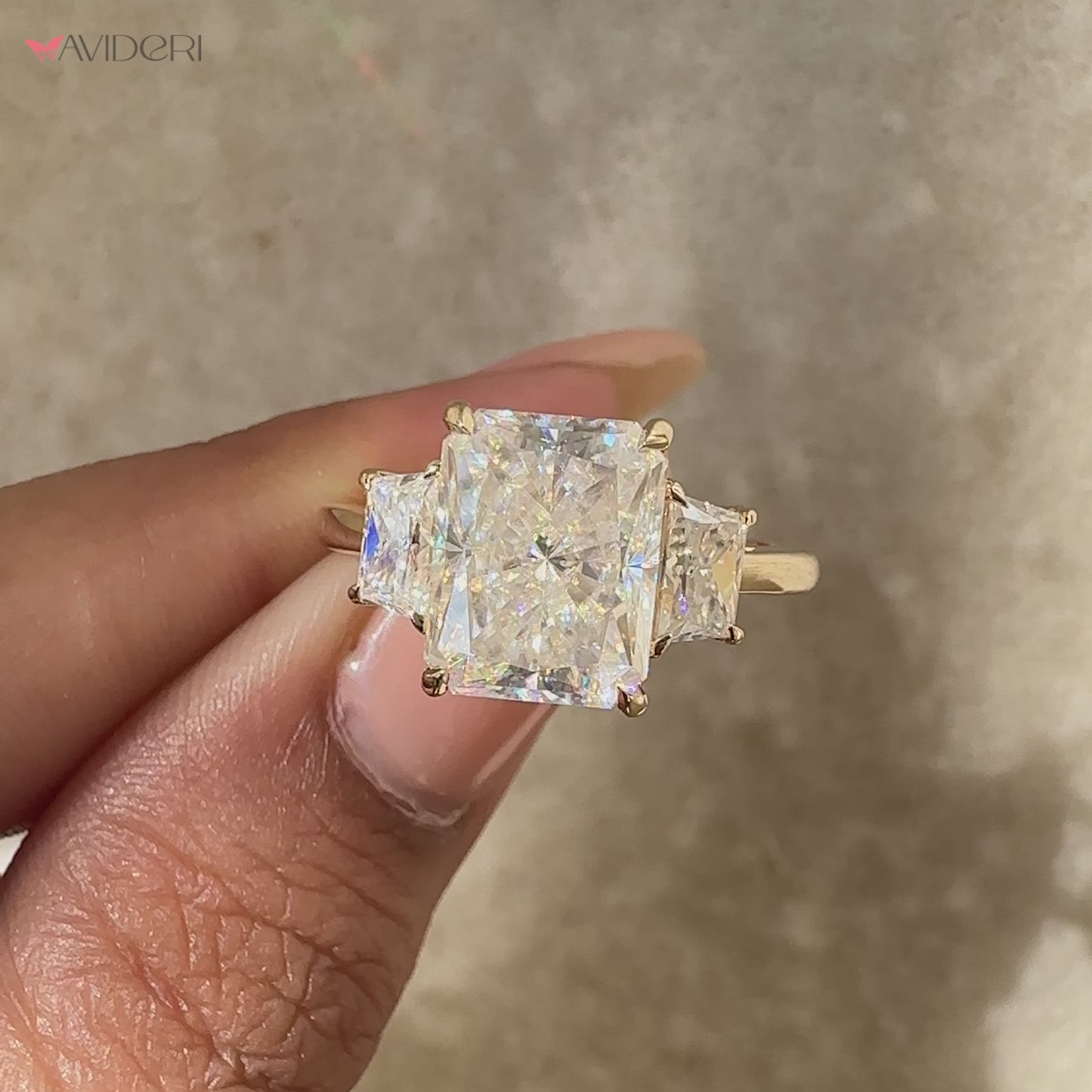 Radiant moissanite ring with balanced three stone design.
