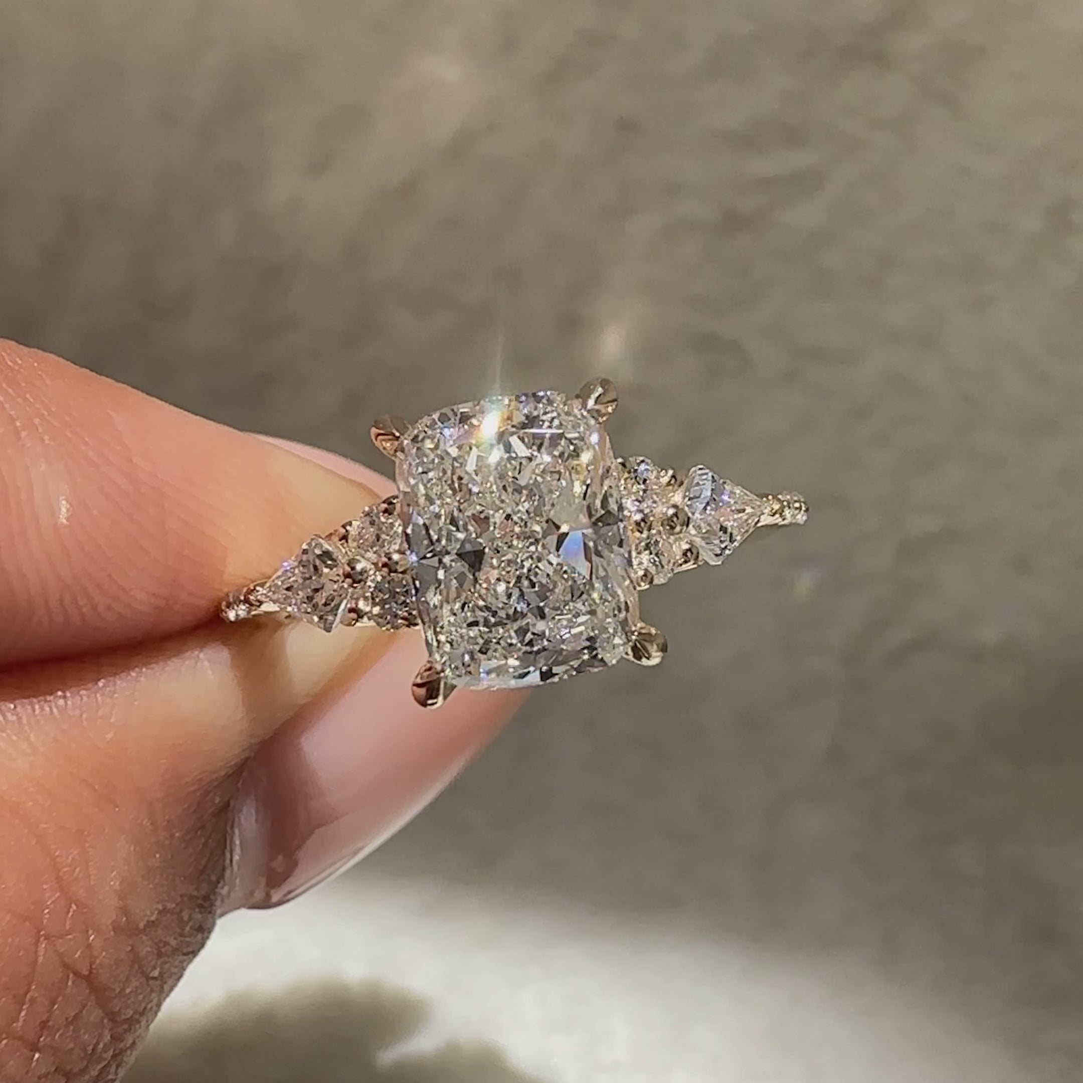 Avideri cushion diamond ring with kite side stone setting.
