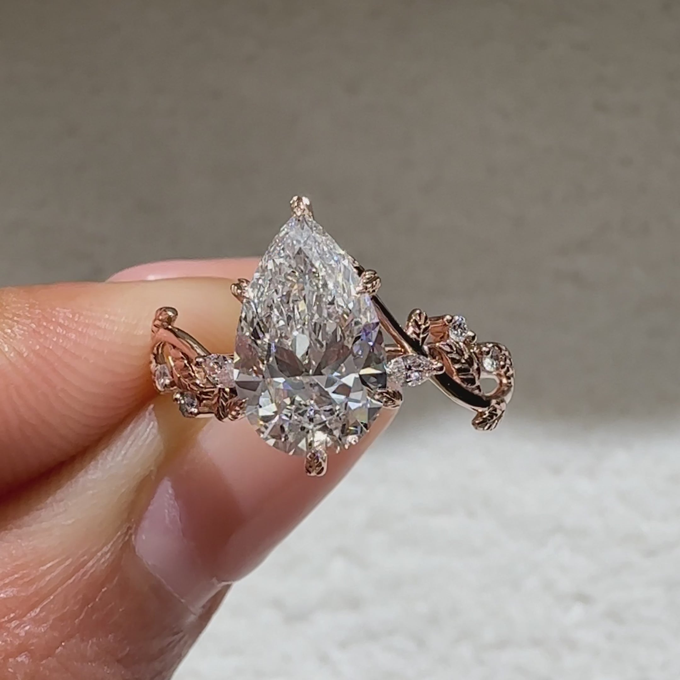 Pear shaped lab diamond ring with decorative leaf prongs
