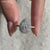 Pear cut halo engagement ring with pavé band in white gold finish.