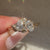 Leaf prong toi et moi ring with round side stones.
