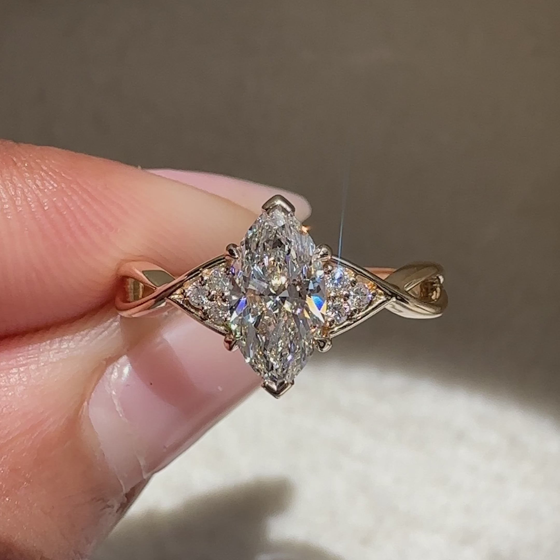 Tapered shank marquise diamond ring with side stones.
