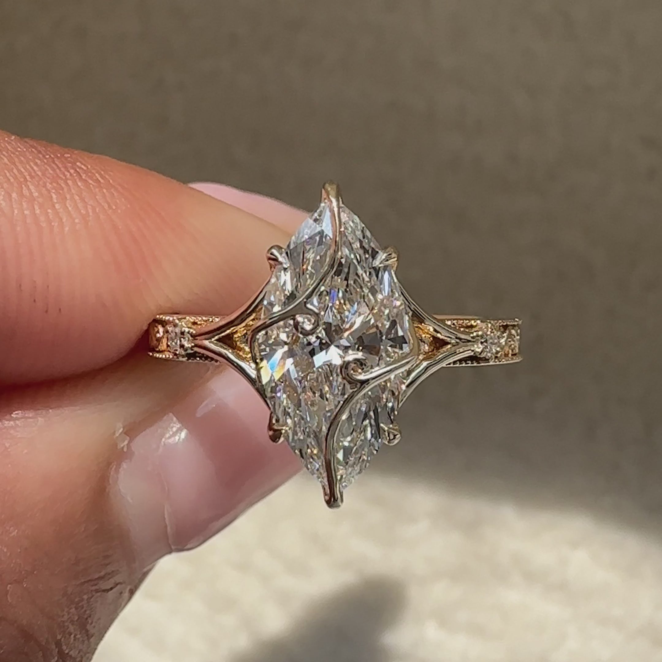 Marquise ring with round stones and split shank.
