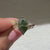 Marquise diamond ring with green center and claw prongs