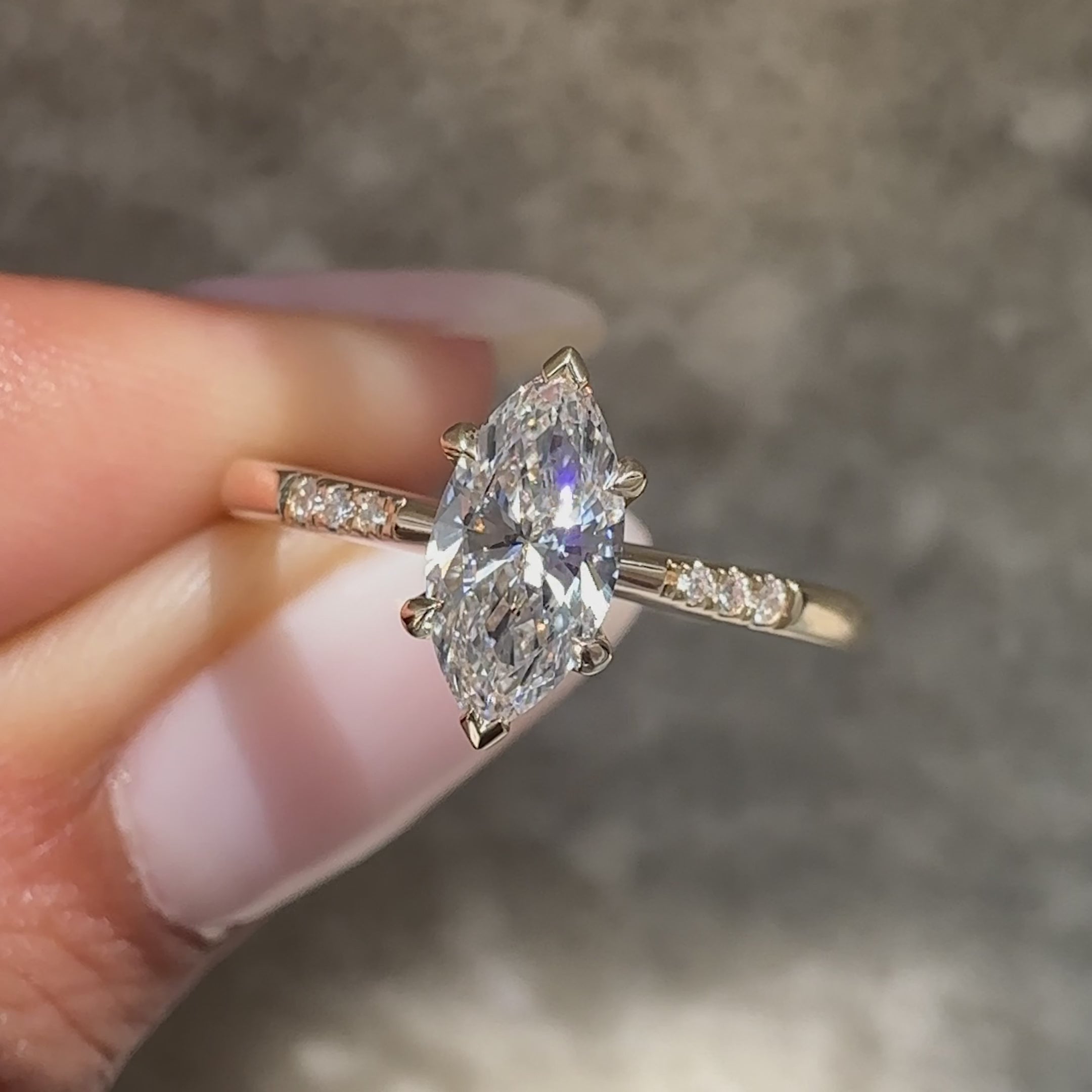 Marquise diamond ring with round diamond pave accents.
