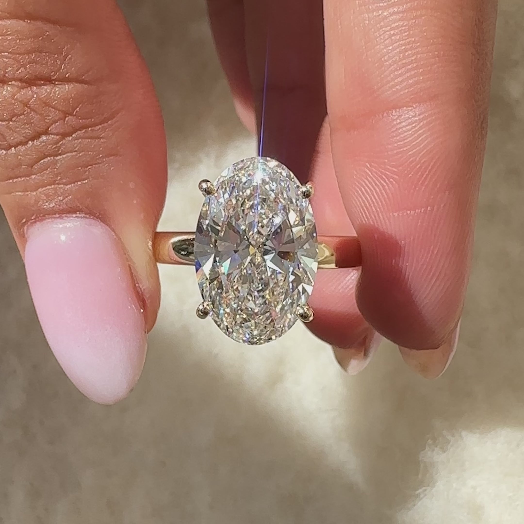 Hidden halo oval diamond ring with four prong setting.
