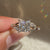 Princess cut diamond ring with round side stones.

