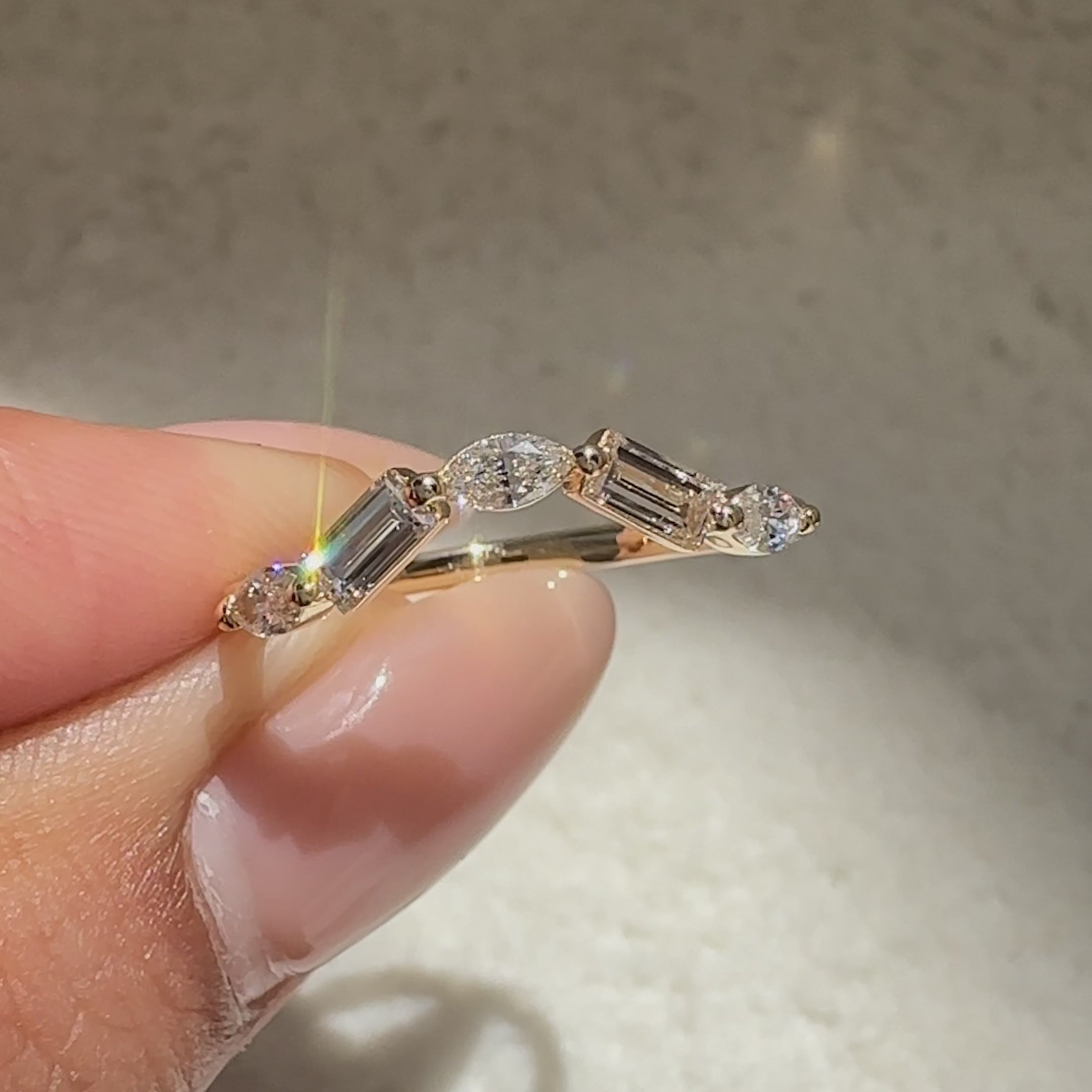 Curved half eternity band with baguette and marquise diamonds.

