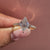 Claw prong lozenge ring with diamond pave.
