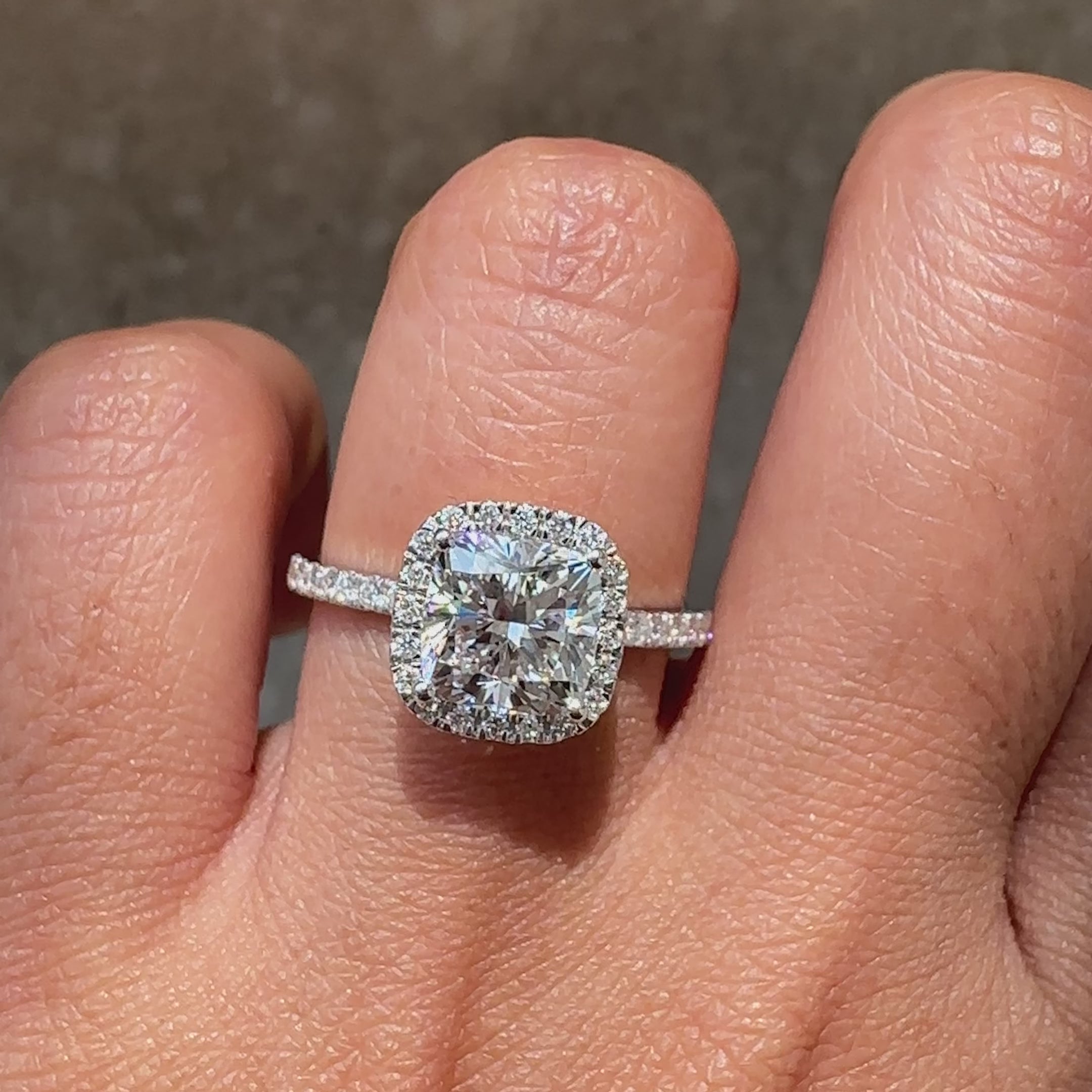Classic cushion diamond ring with halo design.
