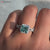 Princess cut moissanite ring featuring a brilliant center stone.
