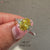 Oval cut yellow diamond ring with marquise and round side stones.