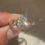 Lab grown oval diamond ring with six leaf prongs.