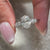 Buy engagement ring with leaf design and round cut side stones in white gold.
