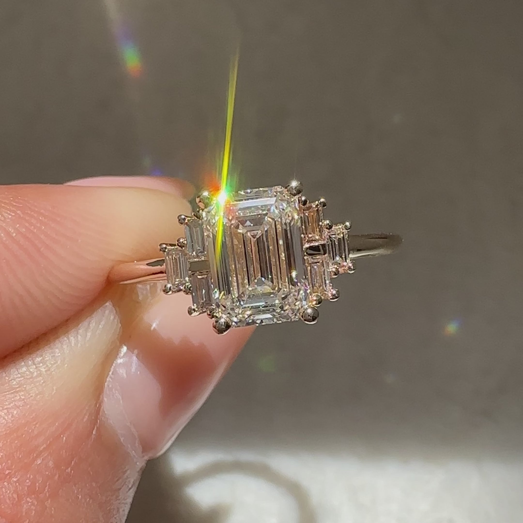 Emerald diamond ring with four prongs and side baguettes
