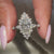custom white gold engagement ring with round cut diamonds and distance pave band.