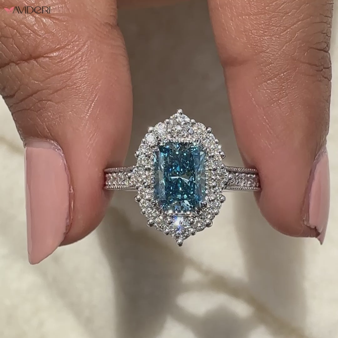 Blue Diamond Ring Held Between Two Finger.