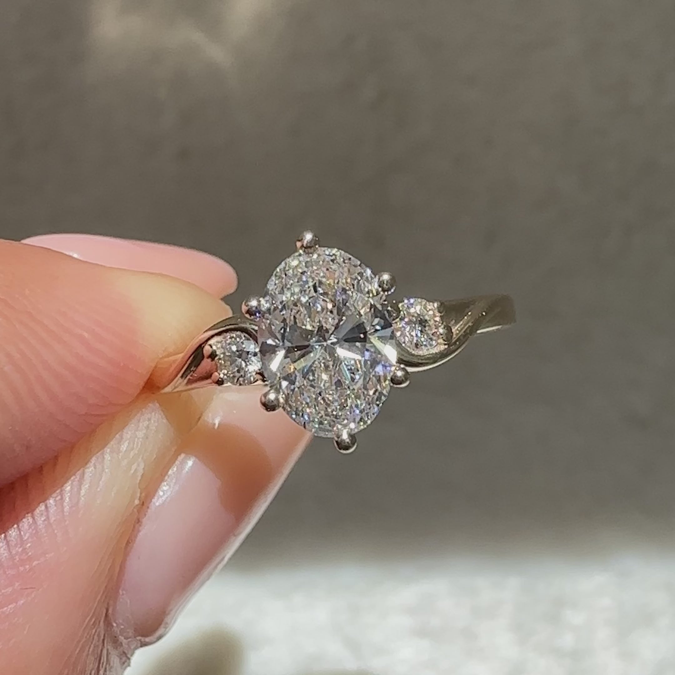 Oval cut ring with six prongs and side stones