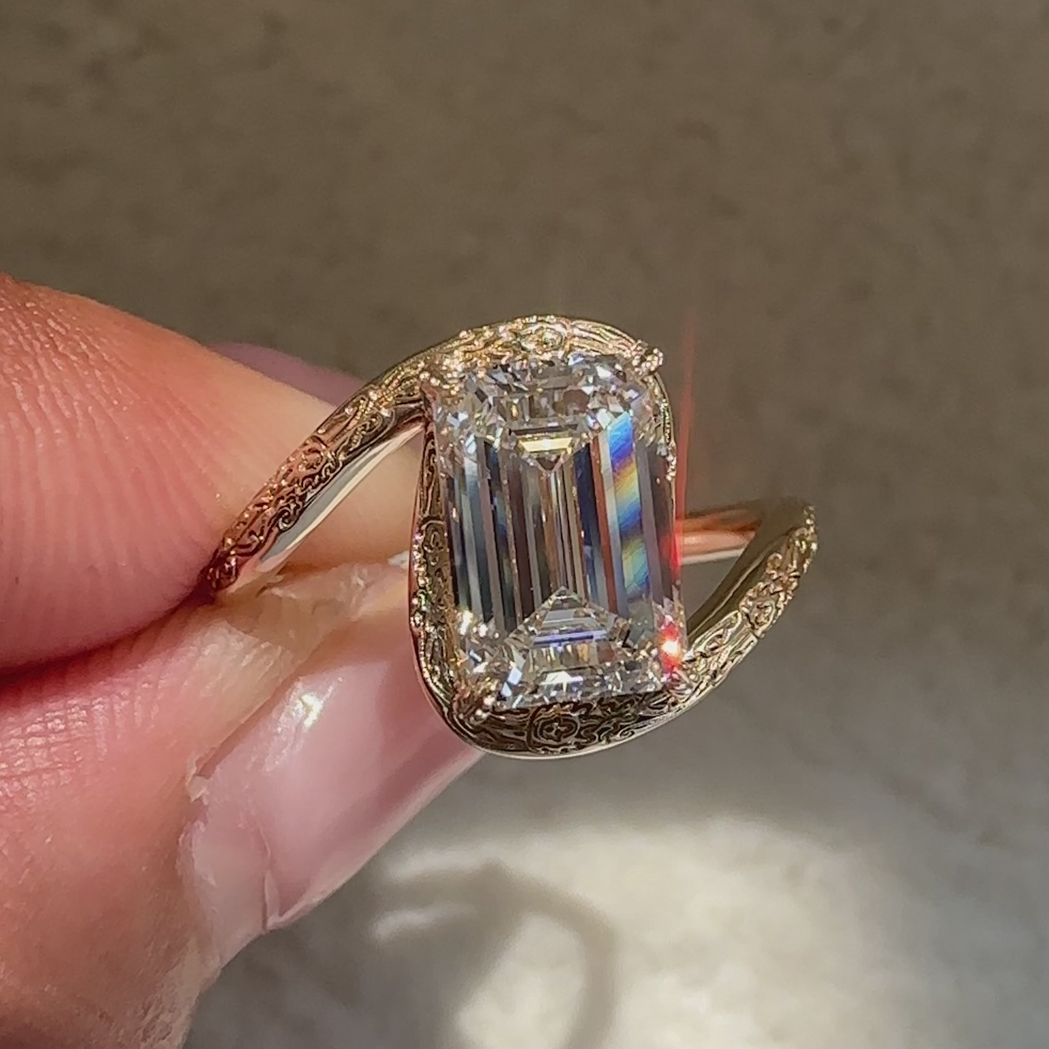 Emerald cut diamond ring with engraved band.
