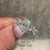 Lab grown oval diamond ring with artistic leaf style prongs.
