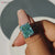 The Ocean Blue Moissanite Engagement Ring shows deep ocean hues.
