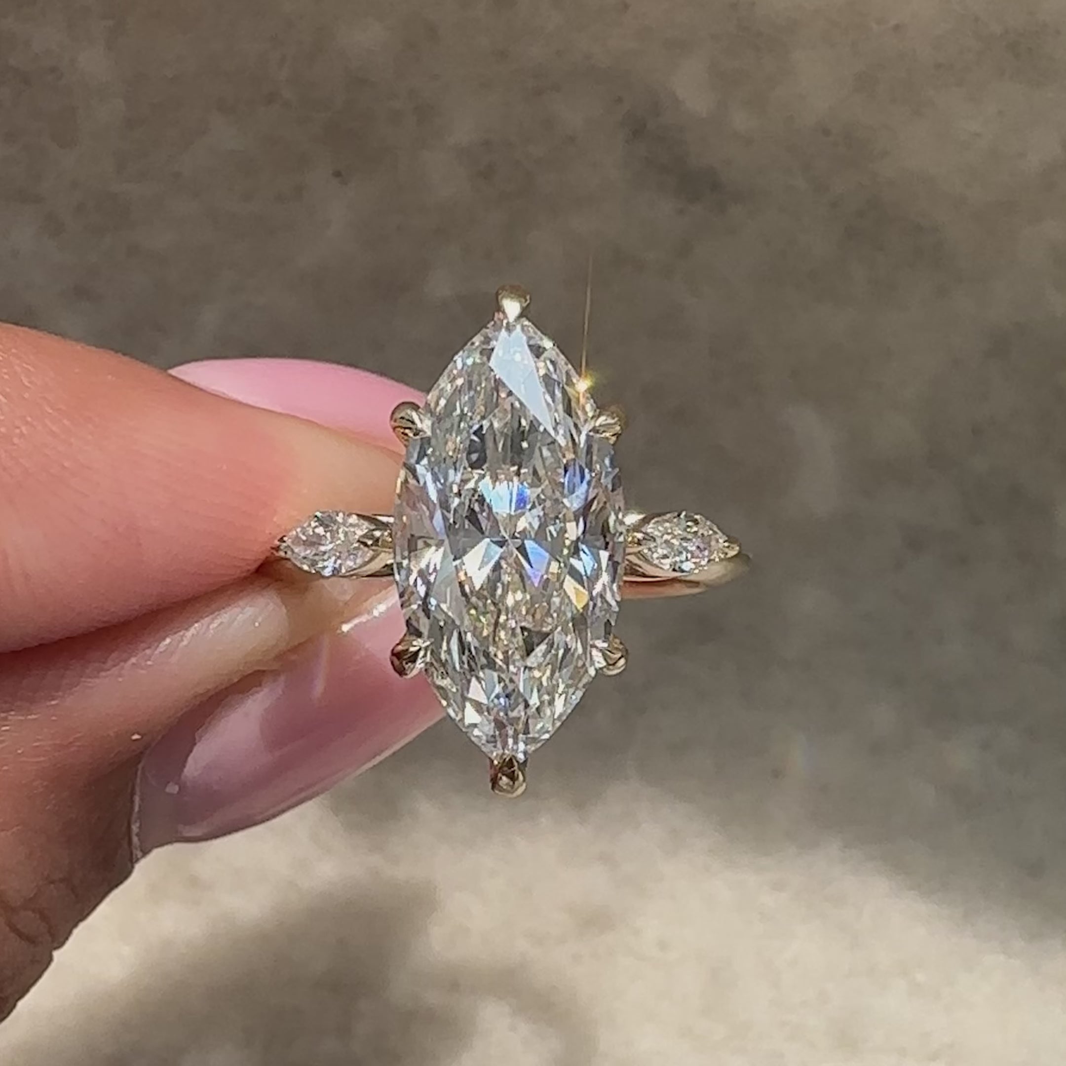 Three stone diamond ring with balanced marquise center and sides.
