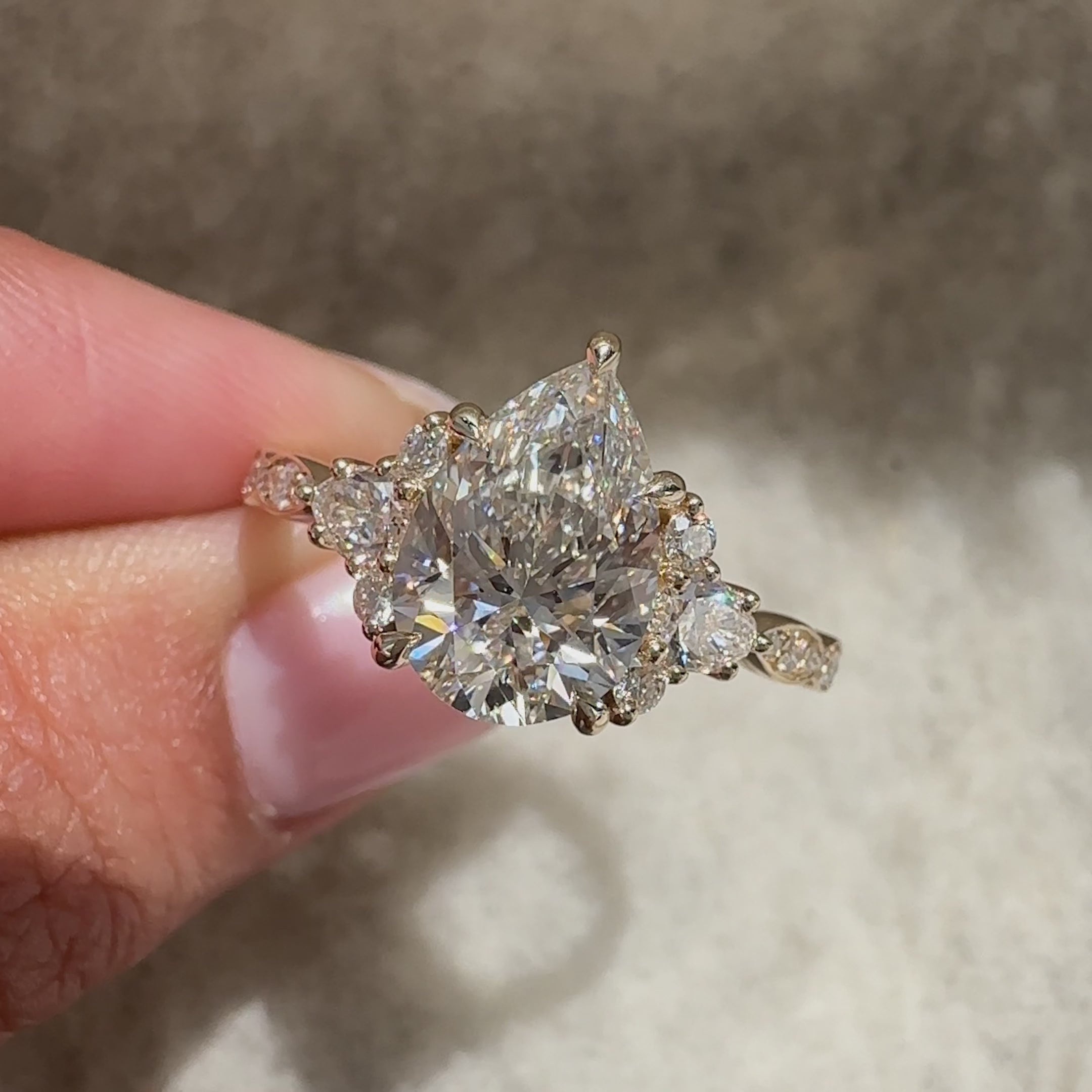Pear cut ring with cluster and pave style.
