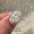 Oval diamond ring with hidden halo and pave accents.