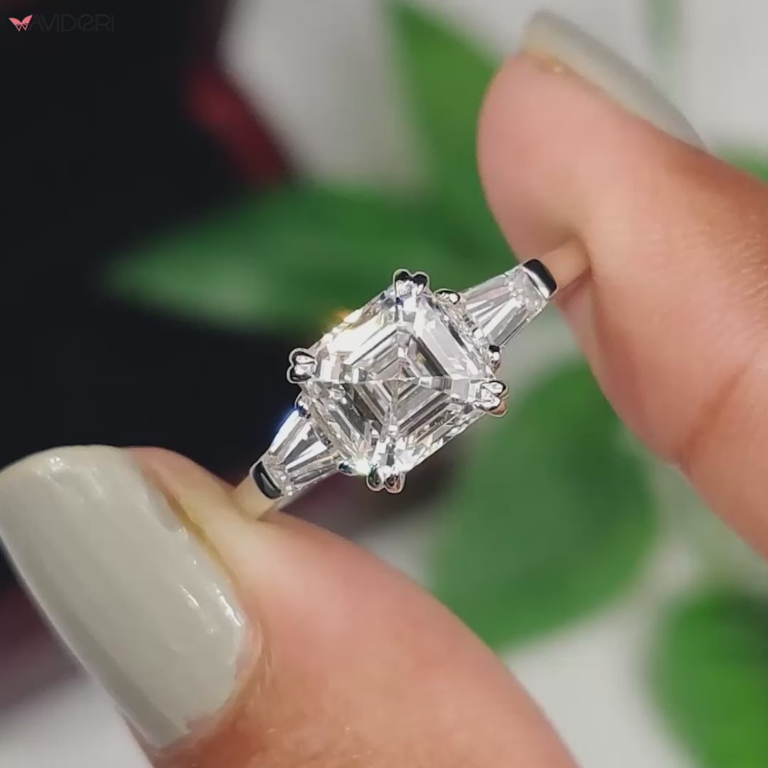 Beautiful 3 stone engagement ring crafted with Asscher diamond and tapered baguette side stones in a unique design.

