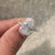 Oval diamond ring with hidden halo and pave accents.