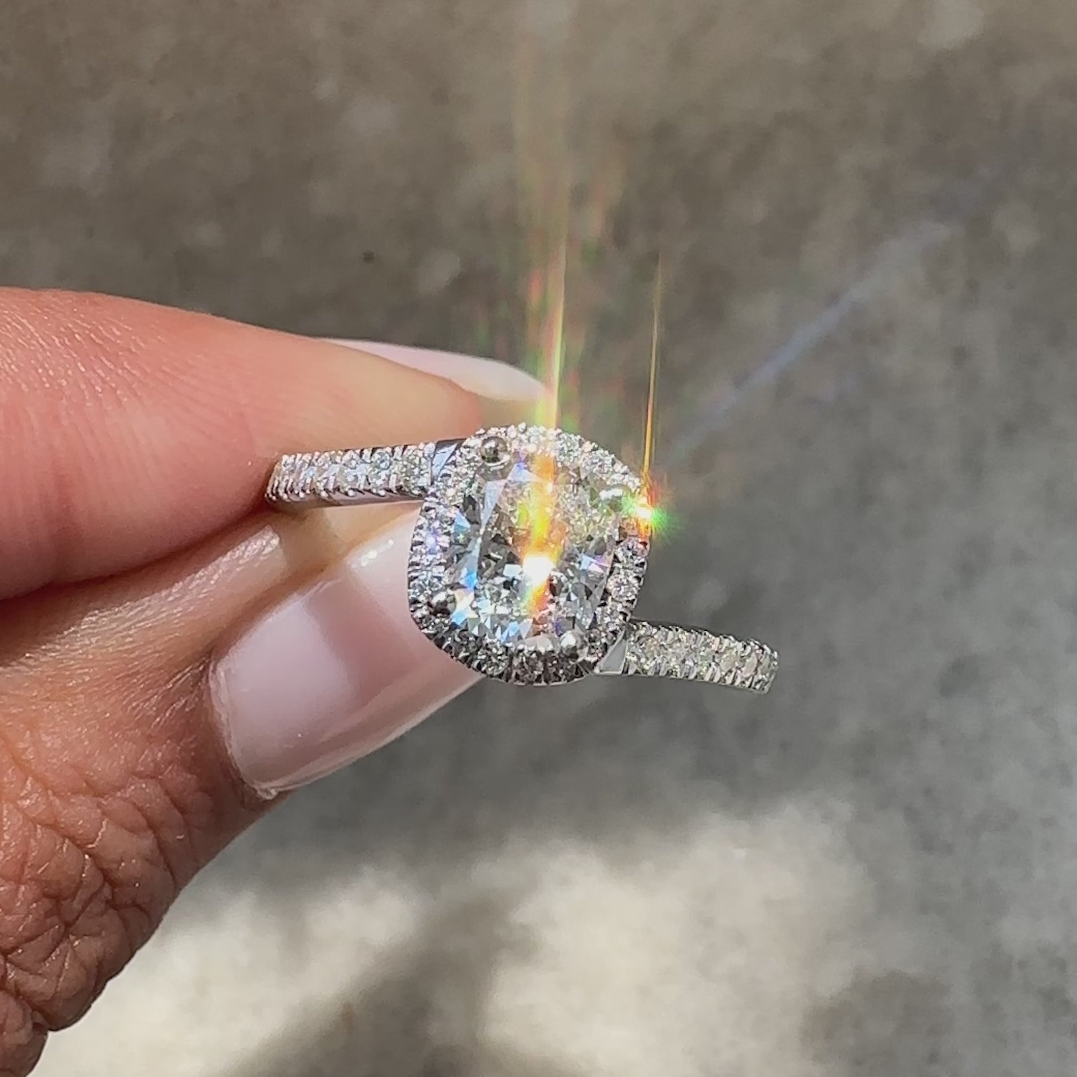 Modern cushion cut diamond ring with halo detail.
