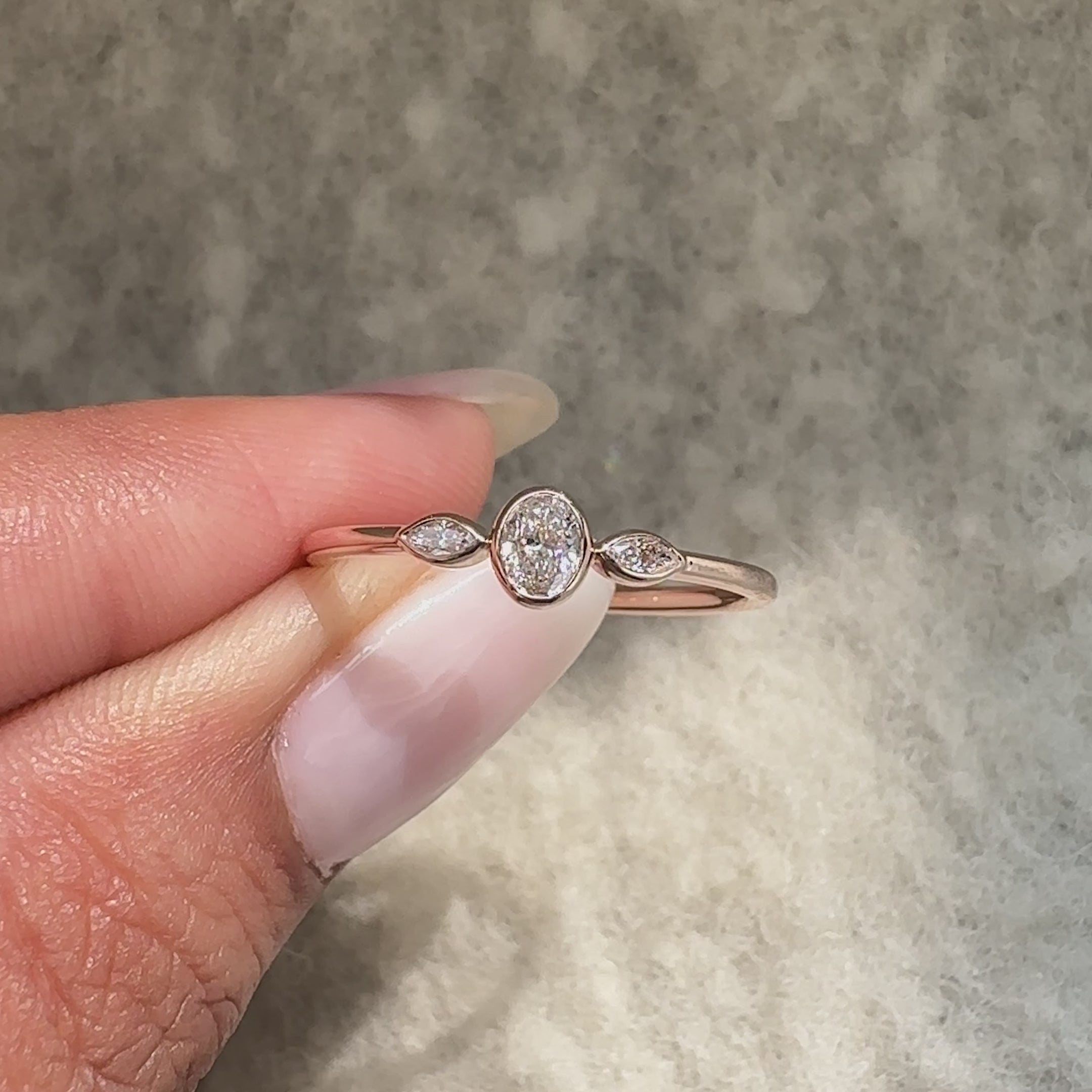Three stone ring with oval cut center diamond and marquise sides.
