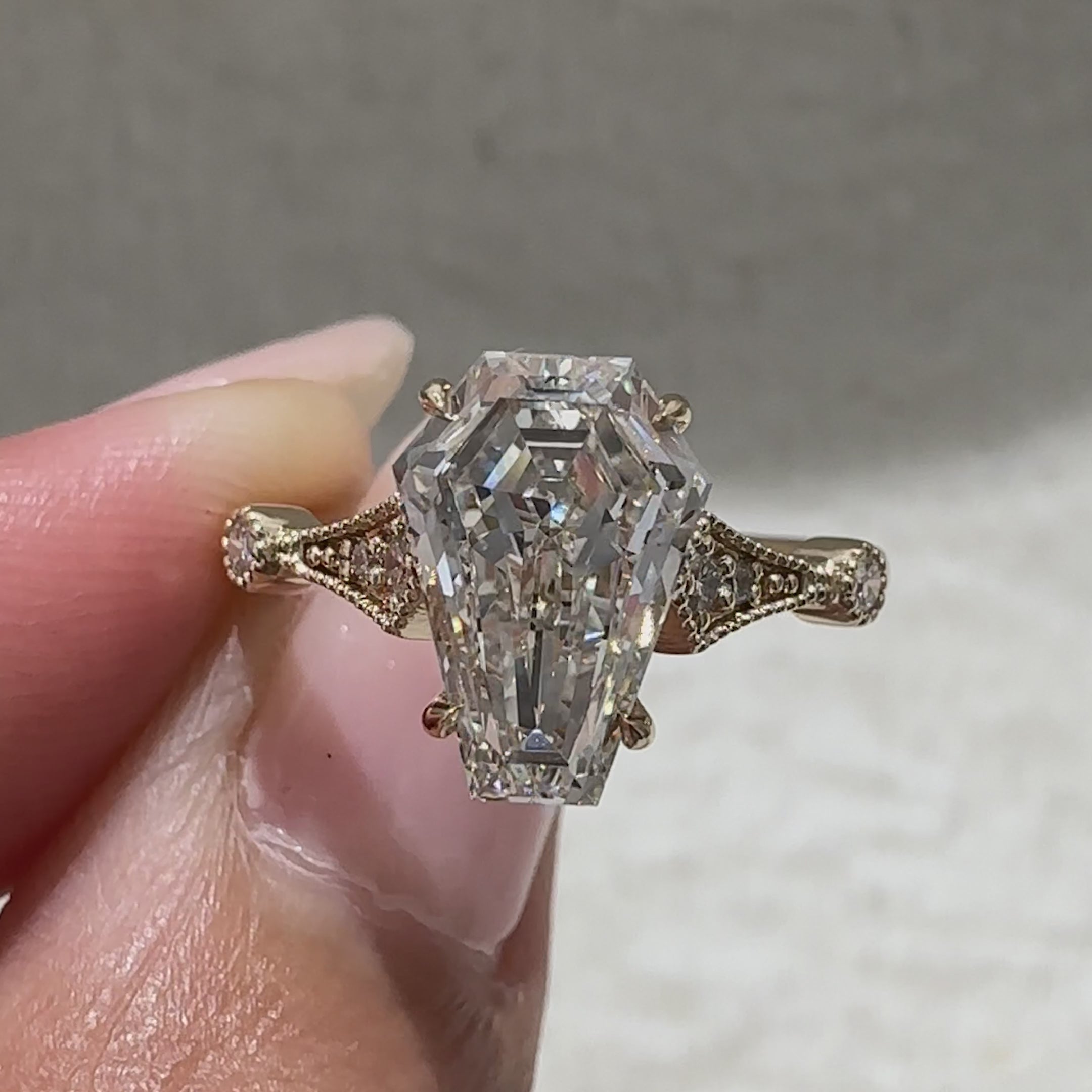Coffin cut engagement ring with round side stones design
